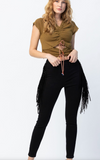 Woman wearing a brown top and black fringed pants on a white background
