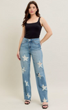 Woman wearing light blue jeans with star patterns on a white background